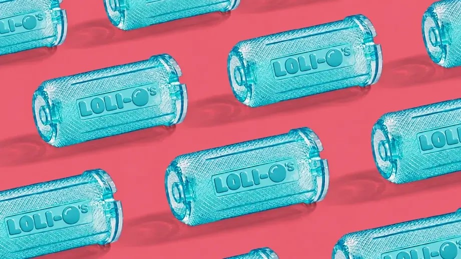 A repeating arrangement of teal Loli-O’s mouthpieces on a pink background.